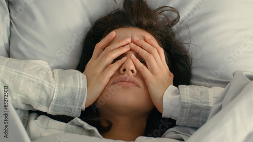 Close up Caucasian young woman touching grabbing face head hands headache migraine feeling illness exhausted expression female in bed unwell tired depression weakness unhealthy tension home frowning