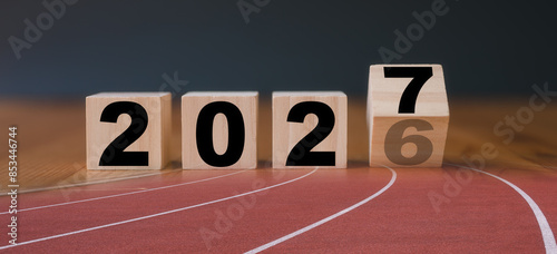 Multi exposure of running track and wooden cube 2026 2027 new year in concept of action business plan targets the new year 2027 growth