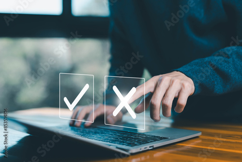 decide to choose to vote check right and wrong marks on a laptop, yes or no decisions. concept of business options for difficult situations, symbols true and false, dilemma. Select the wrong mark sign