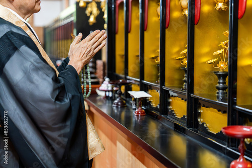 位牌堂で祈る僧侶