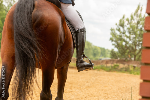 a rider's leg in boots, a man on a horse