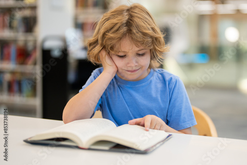 Kid reading book. Child reading book in school library. Learning from books. School education. Back to school Child reading book in a public library.