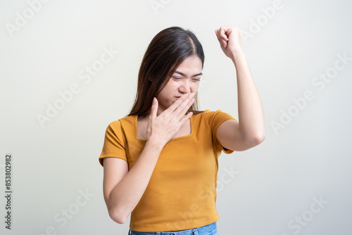 Bad smelling, deodorant asian young woman smell stink, breathing nose smelly on shirt dirty stinky laundry, disgusting from clothes after washed, smelly armpit underarm Medical health, skin body care.