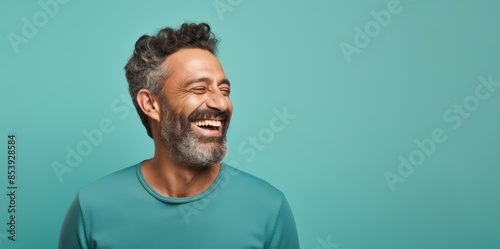  Portrait photo of a happy Middle Eastern man, 46 years old, winking on a pastel teal background