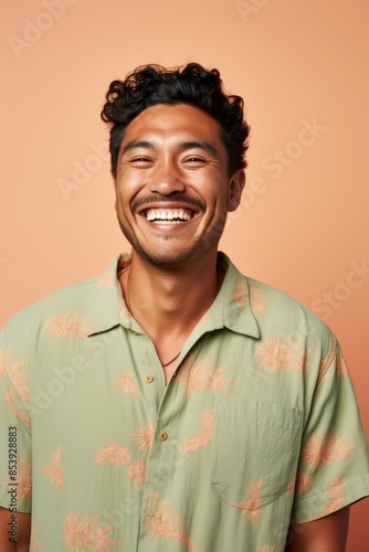  Portrait photo of a joyful Pacific Islander man, 33 years old, winking on a pastel beige background