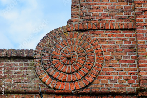 Brick wall with a scroll moulded from bricks as an ornament in the Dutch town of Edam
