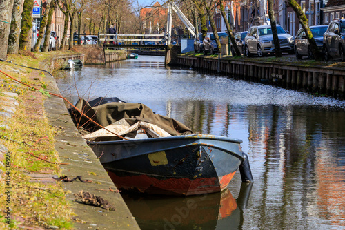 An old barge lies in the water on the banks of a canal in the town of Edam in the Netherlands