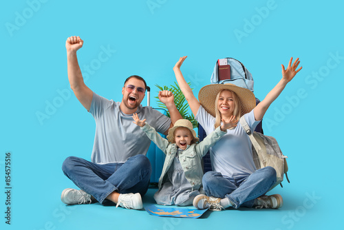 Happy family with suitcase, passport and world map on blue background