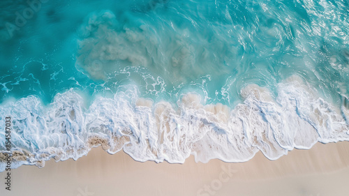 blue ocean waves washing up on a sun-kissed beach, captured from a ariel view