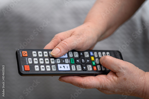Seniorka starsza pani trzyma w dłoniach odlot od telewizora