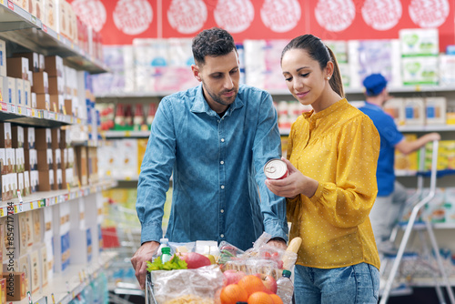 Happy couple doing grocery shopping at the supermarket