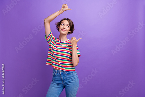 Portrait of charming young lady promoter direct fingers blank space ad ads wear casual clothes isolated purple color background