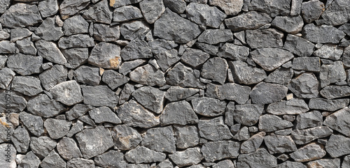 Panoramic texture of natural volcanic stone wall from Tenerife Island, Spain