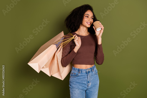 Photo portrait of lovely young lady drink coffee shopping bags dressed stylish brown garment isolated on khaki color background