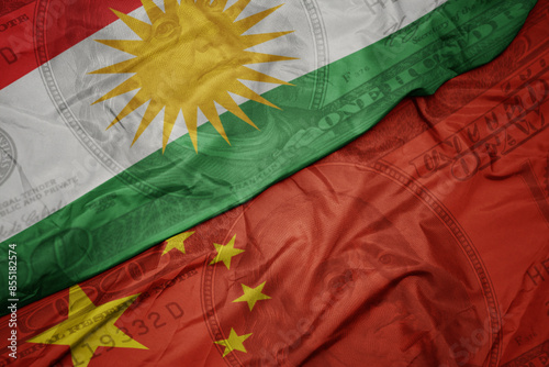 waving colorful flag of kurdistan and national flag of china on the dollar money background. finance concept.