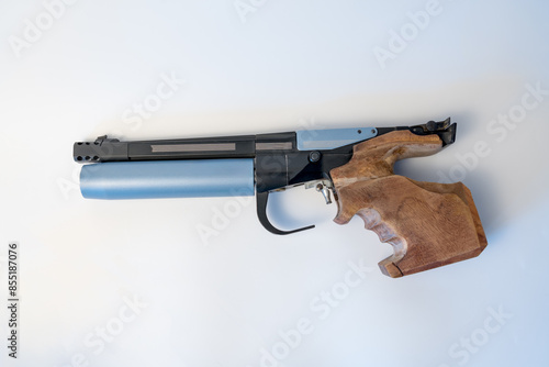  Competition air pistol with custom-made wooden shaped handle and blue air cylinder, on white copy space background