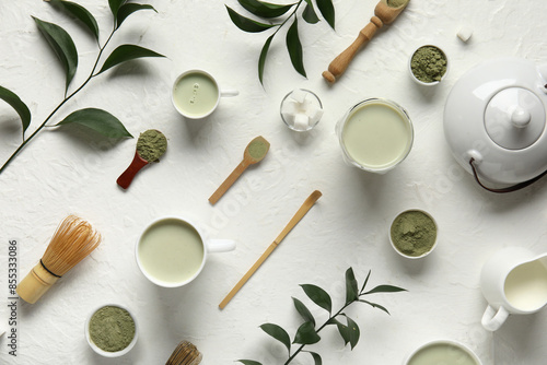 Composition with cups of fresh matcha tea, powder and accessories on light background