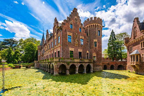 Red brick moated castle “Schloss Paf­fen­dorf“ in Bergheim near Cologne (Germany) with its his­tor­ic­al am­bi­en­ce and splendid parks is a popular tourist attraction, monument and idyllic sight. 
