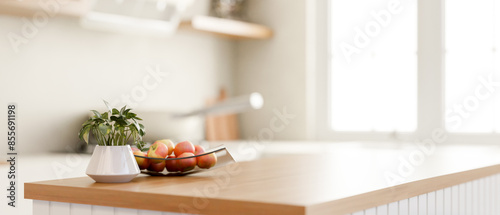 A close-up image of a wooden kitchen island with a copy space in a modern bright and clean kitchen.