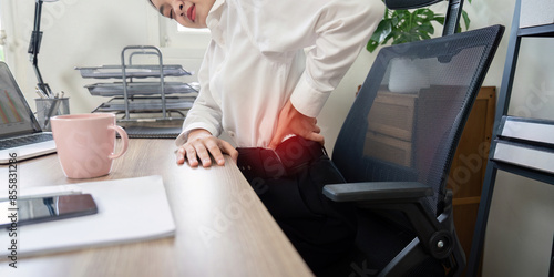 Business Professional Experiencing Back Pain at Office Desk. Workplace Health and Ergonomic Concept