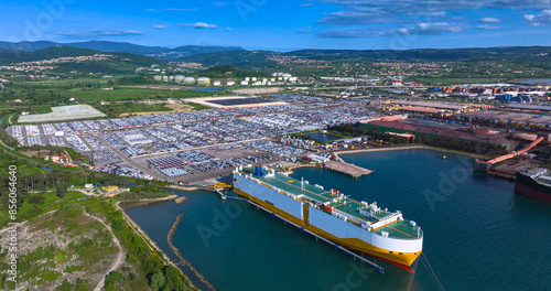 AERIAL: Panoramic view of the Koper port and a massive cargo ship unloading.