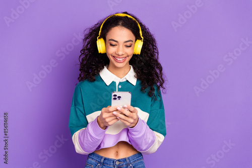 Portrait of lovely young girl smart phone headphones wear shirt isolated on purple color background