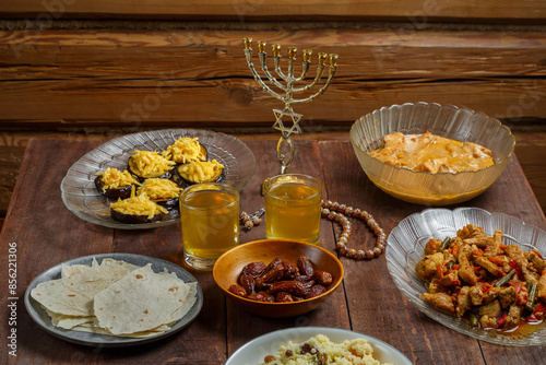 Shabbat table for a family meal with traditional holiday dishes and drinks. Horizontal photo.