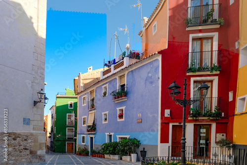 View to beautiful narrow Villajoyosa street with multi-colored houses. La Vila Joiosa - coastal town, Valencian Community, Spain, by Mediterranean sea
