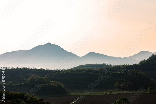 vista dettagliata di alcune alte colline in veneto, avvolte da della nebbia, di giorno, al tramonto