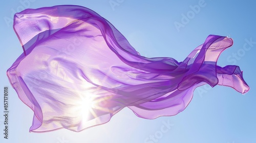 Flowing purple fabric in bright sunlight, against clear blue sky