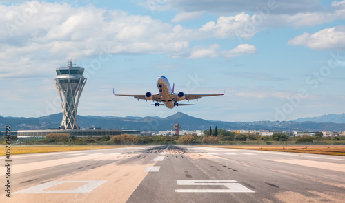 White Passenger plane fly up over take-off runway from airport - El Prat-Barcelona airport. This airport was inaugurated in 1963 - Barcelona, Spain