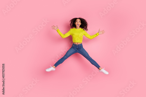 Full body length photo of sporty youth funny girl wearing green sweater and jeans jumping showing star figure isolated on pink color background
