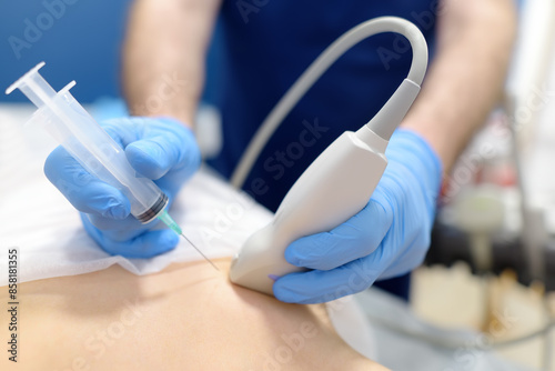 Mammalogist doctor examines woman breasts and lymph nodes during appointment. Skillful oncologist puncture of mammary glands of young patient under review ultrasound for diagnosis of breast cancer