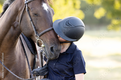 Young equestrian girl woman with horse equine in english tack and riding attire hunter jumper