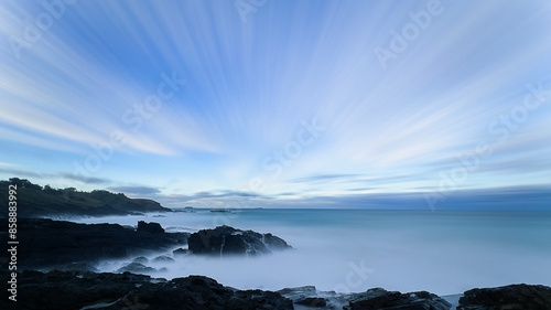 Abstract shiny blue sunray over the pacific ocean with cool winter coastline view.