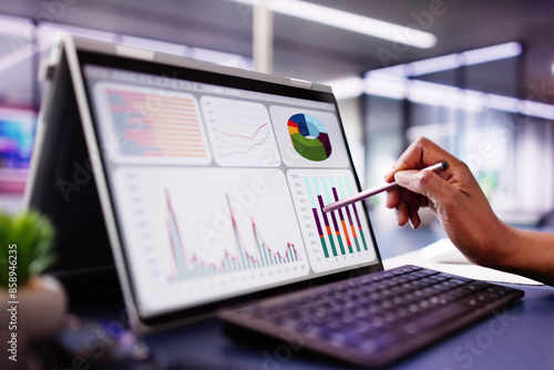 African American woman analyzing financial data on laptop screen