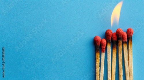 Brown matches on blue background one burning brightly Space for inscription conveys victim and hard work