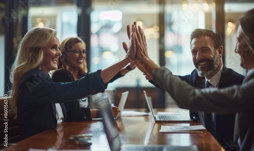 Successful business people celebrating with a high five gesture in a boardroom
