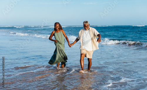 Joyful senior couple walking by the sea