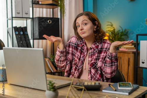 I don't know what to say. Confused businesswoman working on laptop at office workplace. Freelancer feeling embarrassed about ambiguous question having doubts, no answer idea, being clueless, uncertain