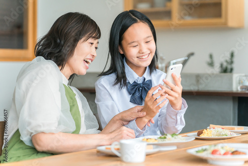 ママと一緒にスマホ・スマートフォンを見る子供・中学生・高校生 