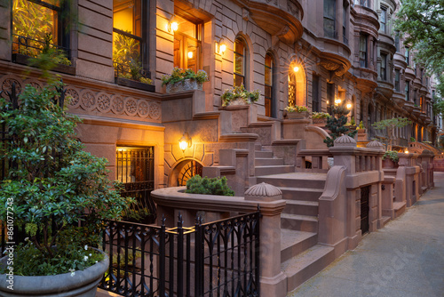 Evening view of iconic New York City brownstones with stoop steps on Upper West Side of Manhattan. This row of brownstones is located in Central Park West Historic District