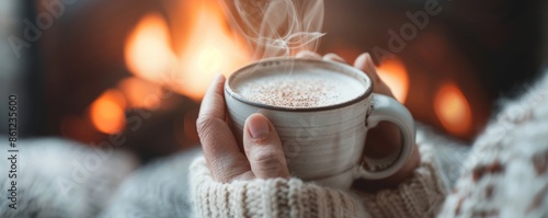 Cozy setup with warm drink held in hand while relaxing by the fireplace, capturing the essence of comfort and warmth.