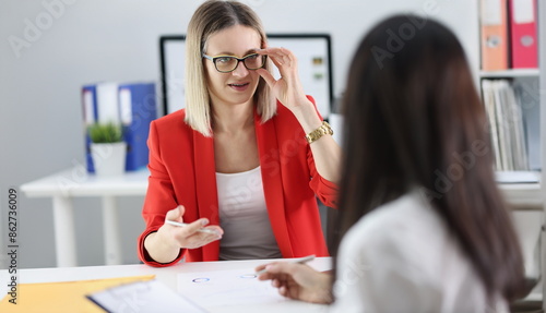 Two businesswoman chatting at working table. Business communication with colleagues concept