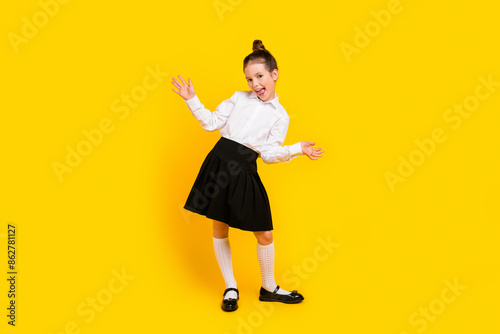 Full body photo of cute schoolgirl have good mood dance wear uniform isolated on yellow color background