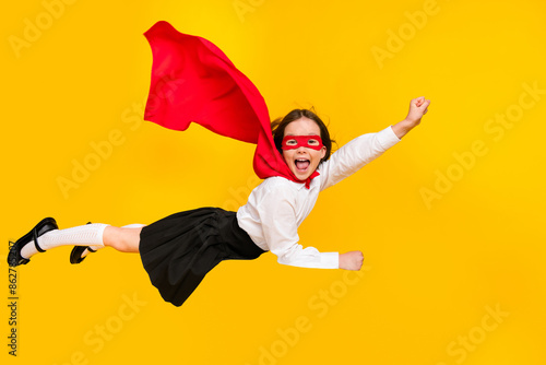 Full body photo of cute super girl raise fist flying wear uniform isolated on yellow color background