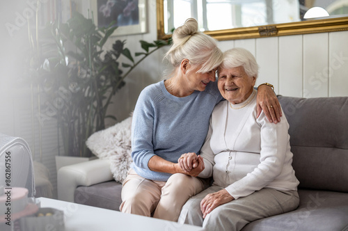 Happy senior woman with her adult daughter at home 