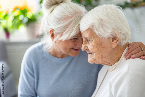 Happy senior woman with her adult daughter at home 