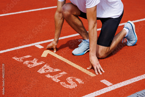 Athlete at starting line readies for sprint, focusing on race and preparing for successful start