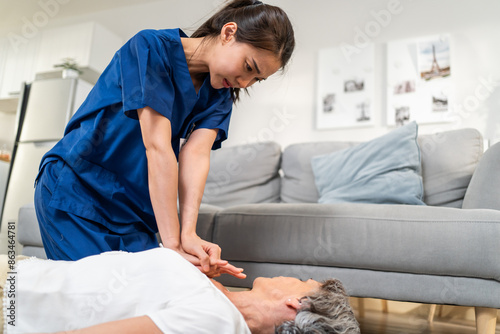 Asian caregiver saving senior woman's life by doing cpr in emergency.